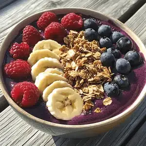 Smoothie bowl with banana, raspberries, blueberries and granola